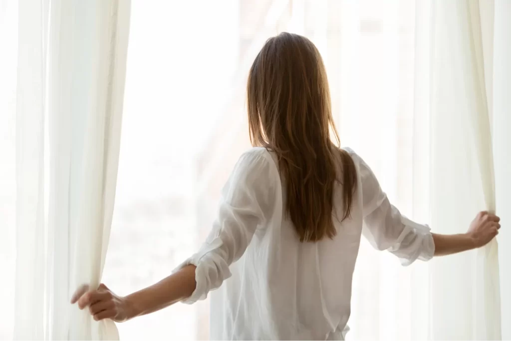 女性が窓を開けている様子